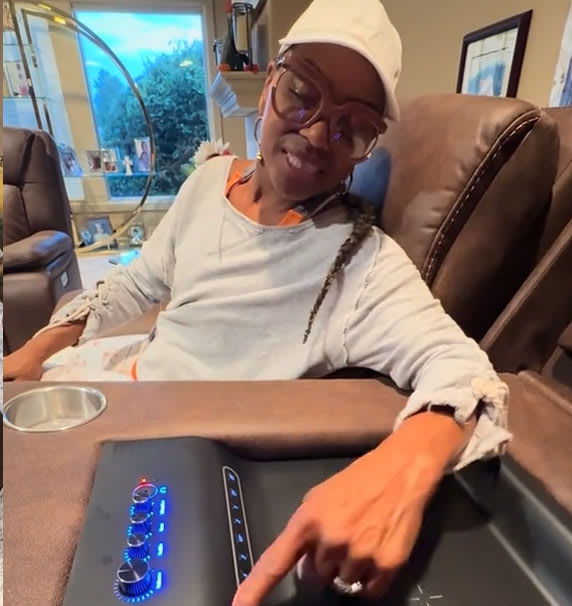 Brown Leather looking reclining sofa with controls panel in living room. Women pushing buttons.